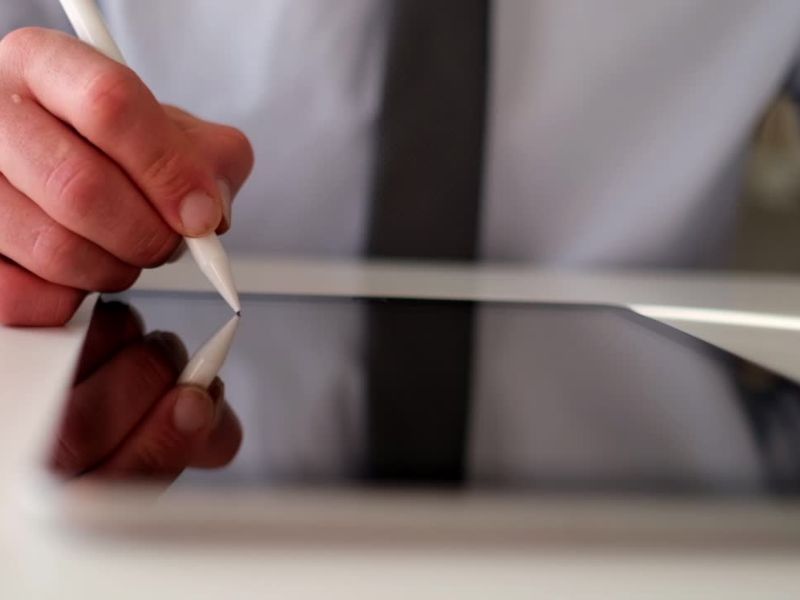 čovek koristi tablet i olovku i unosi nešto u tablet