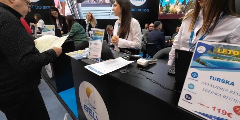 Predstavnici kompanije razgovaraju sa posetiocima na Beogradskom sajmu na uređenom sajamskom štandu