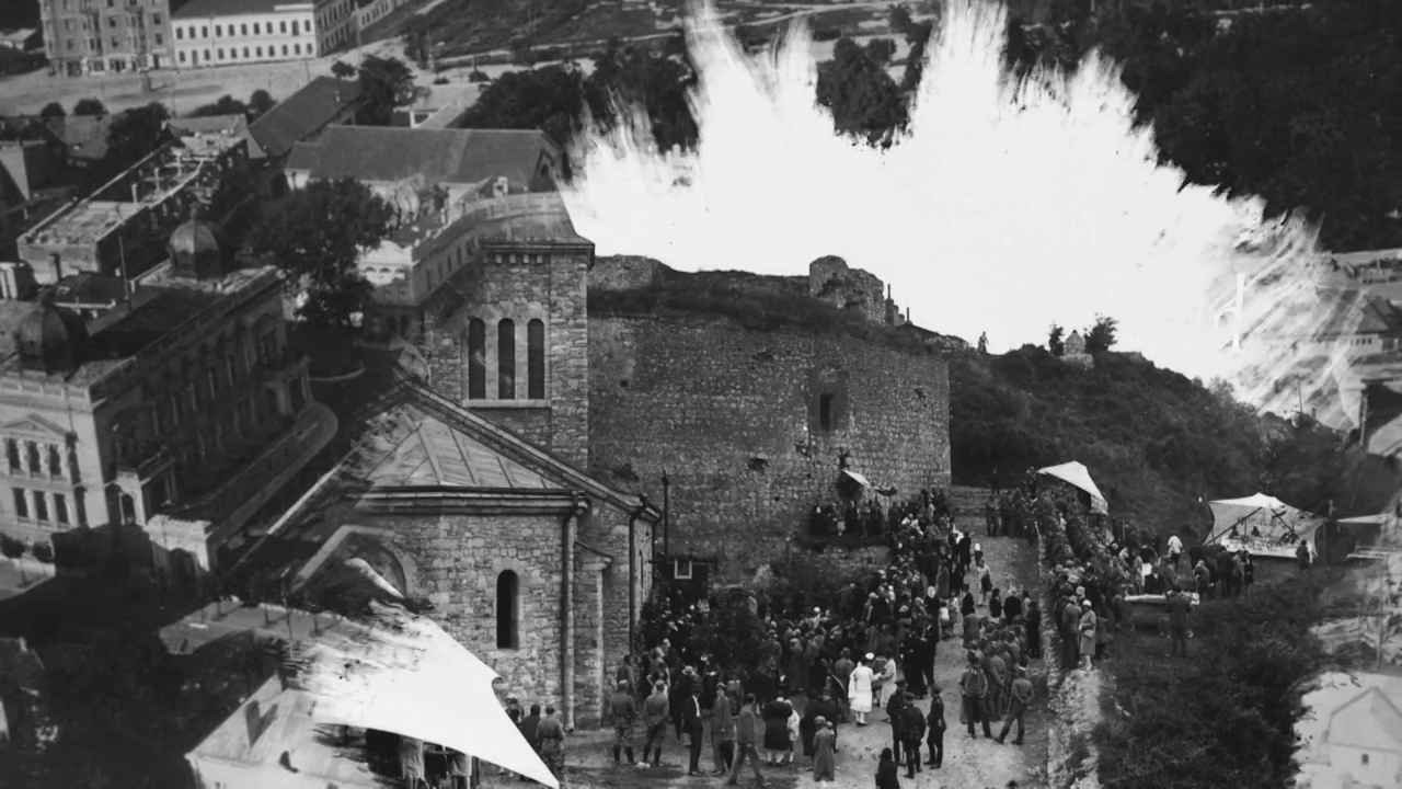 Crno-bela istorijska fotografija Beogradske tvrđave sa okupljenim ljudima i velikom eksplozijom u pozadini.